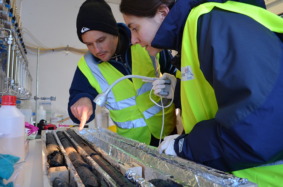Lamont adjunct geochemist Juerg Matter (left) and microbiologist Rosalia Trias of the Paris Institute of Earth Physics, scientists working on the CarbFix project in Iceland, inspect basalt cores for solidified carbon dioxide. (Kevin Krajick/Lamont-Doherty Earth Observatory)