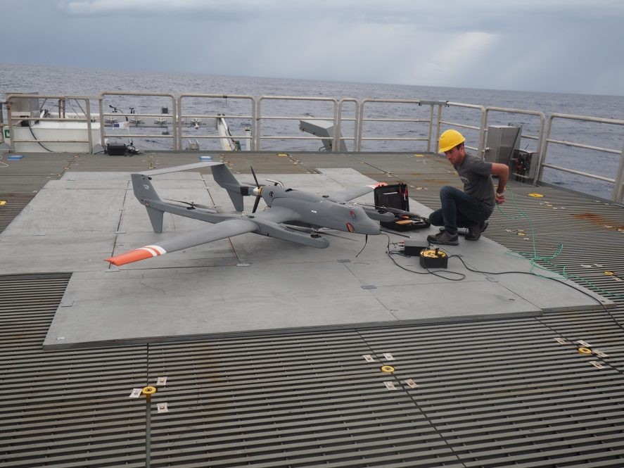 Scott Brown, an engineer at Lamont, prepares a scientific instrument payload for a drone being deployed from a research vessel. (Image: Chris Zappa)