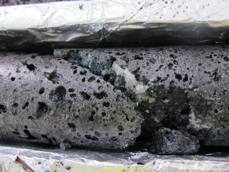 The fracture in this basalt rock shows the white calcium carbonate crystals that form from the injection of CO2 with water at the test site. (Photo: Annette K. Mortensen) The fracture in this basalt rock shows the white calcium carbonate crystals that form from the injection of CO2 with water at the test site. (Photo: Annette K. Mortensen)