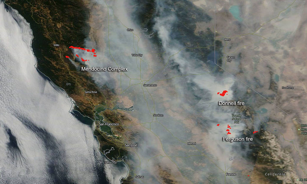 A satellite image, August 6, 2018, shows smoke from multiple large California wildfires. The fires themselves, detected by thermal imagery, are in red. (NASA)